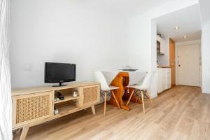a living room with a tv and a table and chairs at Pet Friendly + Pool + Park, Beach 2 Minutes Away (Atalaya) in Salou