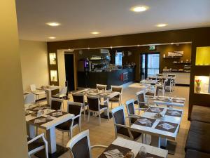 a restaurant with tables and chairs and a kitchen at Hotel 325 Tor Vergata in Tor Vergata