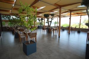 a restaurant with wooden tables and chairs and plants at Nur Hotel in Kaş