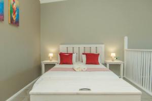 a bedroom with a large white bed with red pillows at Accommodation on 3329 - Unit 3 in Gqeberha