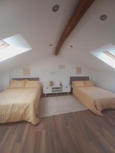 two beds in a attic room with skylights at Lar da avoa in Ouviaña