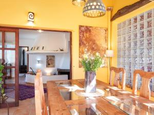 a dining room with a wooden table and yellow walls at Flor de Besso in Llucmajor