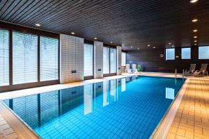 a large swimming pool in a building at Rosels Mountain Lodge - Ferienwohnung mit Schwimmbad, Sauna & Bergblick - Oberaudorf Bayern in Oberaudorf