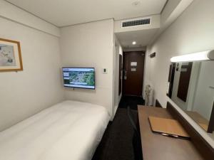 a hotel room with a bed and a television at Hotel Alpha-One Niihama in Niihama