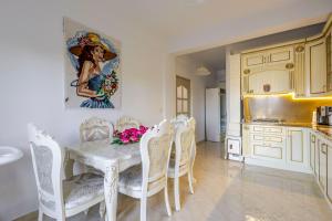 a kitchen with a table with chairs and a painting on the wall at Vila Dy Bukurite Durres in Draç