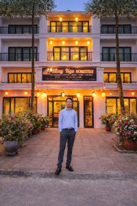a man standing in front of a building at HangNga homestay - hotel in Phủ Từ Sơn
