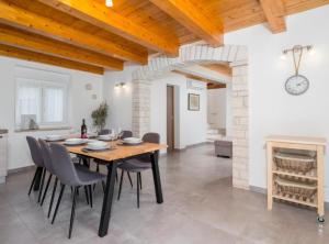 a dining room with a table and chairs and a fireplace at Villa Prestige Azinetti with Pool in Štokovci