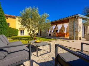 a patio with a couch and a table in a yard at Villa Prestige Azinetti with Pool in Štokovci