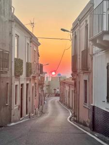 an empty street with a sunset in the distance at Superior Stone in Venetico