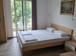 a bed in a room with a large window at Villa Ponta in Kaluđerac