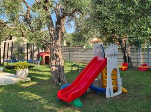 a playground with a slide and a tree at Villa Ponta in Kaluđerac