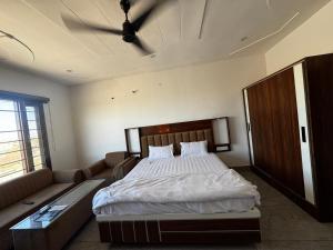 a bedroom with a bed and a couch at Hotel HB Grand in Anūpgarh +1 photo