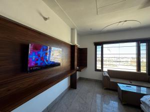 a living room with a tv on a wall at Hotel HB Grand in Anūpgarh