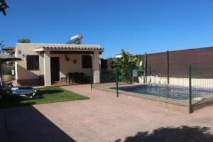 a house with a fence around a swimming pool at Casa Lucia Conil in Conil de la Frontera