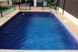 a large swimming pool with blue water at Casa Lucia Conil in Conil de la Frontera