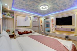 a bedroom with a large bed and a flat screen tv at Hotel Armani Suites-Free Airport Drop in New Delhi