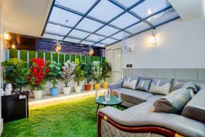 a living room with a couch and some plants at Hotel Armani Suites-Free Airport Drop in New Delhi
