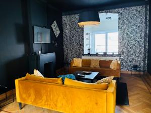 a living room with a yellow couch and a table at La Villa Delsa in Namur