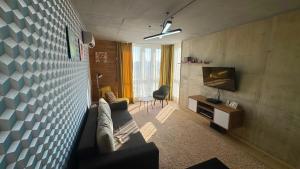 a living room with a couch and a tv at Smart apartment -Має Резервне живлення in Yuzhne