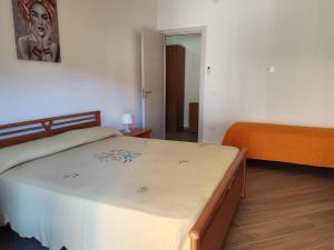 a bedroom with a bed with a white bedspread at Appartamento Serenity in Marina di Ascea