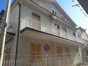 a white building with a balcony and a street sign at Appartamento Serenity in Marina di Ascea