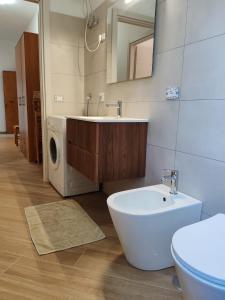 a bathroom with a sink and a washing machine at Appartamento Serenity in Marina di Ascea