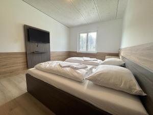 a bedroom with two beds and a flat screen tv at A2 Hotel Memmingen - SELF-CHECK-IN in Memmingen +4 photos