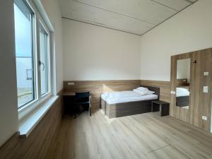 a bedroom with a bed and a desk and a mirror at A2 Hotel Memmingen - SELF-CHECK-IN in Memmingen