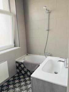 a bathroom with a sink and a bath tub at La Villa Delsa in Namur +10 photos