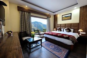 a bedroom with a large bed and a large window at The Summerlead, Shimla in Shimla
