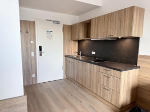 a kitchen with wooden cabinets in a room at A2 Hotel Memmingen - SELF-CHECK-IN in Memmingen