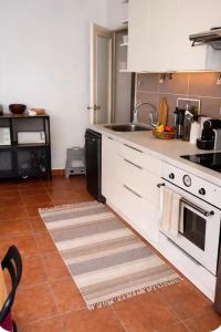 a kitchen with white cabinets and a stove top oven at Loft cosy au portes d'avignon in Les Angles Gard