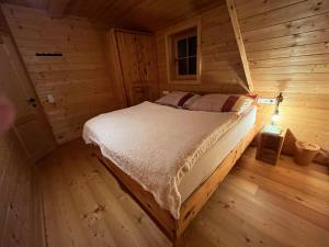 a bedroom with a bed in a wooden cabin at TANAs Almhütte in Flattnitz