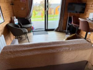 a living room with a couch and a television at Squirrel's Drey in Torphichen