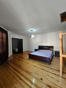 a bedroom with a bed and a wooden floor at Home in Ancient District in Tbilisi City