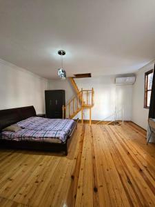 a bedroom with a bed and a wooden floor at Home in Ancient District in Tbilisi City