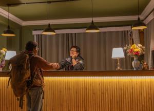 a man helping a woman at a bar at Trippers CastleWoods in Darjeeling
