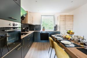 a kitchen with a wooden table and blue cabinets at Nebbiu - 25km de Bastia in Murato