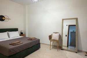 a bedroom with a bed and a mirror and a chair at Olea Blue Suite in Stalís