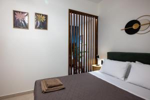 a bedroom with a bed with a clock on the wall at Olea Blue Suite in Stalís