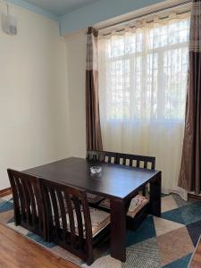 a dining room with a table and chairs and a window at Spring Grove B&B in Jowai