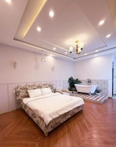 a bedroom with a large bed and a bath tub at GÓC MƠ home in Da Thanh