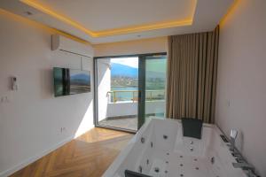 a room with a bath tub with a large window at Murati Lake View Hotel in Tirana