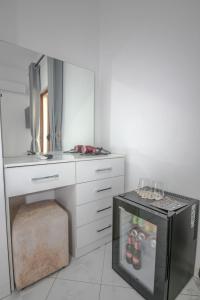 a kitchen with a refrigerator and a counter with shoes in it at Murati Lake View Hotel in Tirana