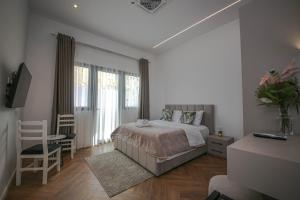 a bedroom with a bed and a table and chairs at Murati Lake View Hotel in Tirana