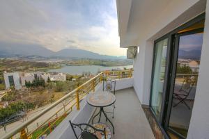 a balcony with a table and a view of a river at Murati Lake View Hotel in Tirana