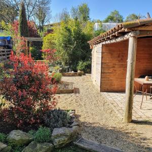 a garden with a wooden pergola and a patio at Auró Blanc- Allotjament Turístic in L’ Esquirol