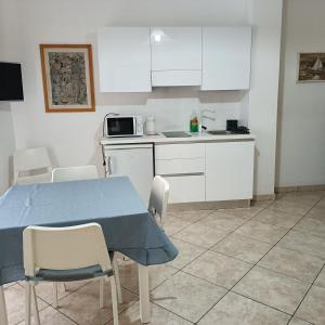a kitchen with a table and chairs and a microwave at Nonnacettyhouse in Torre del Greco +18 photos