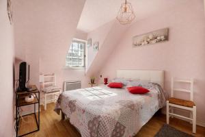 a bedroom with a bed with red pillows on it at Chambre d'hote Reine in Cancale