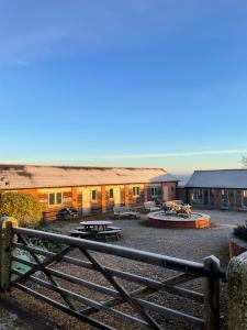 a group of buildings with a fence in the foreground at Cool Contours Venue in Eydon